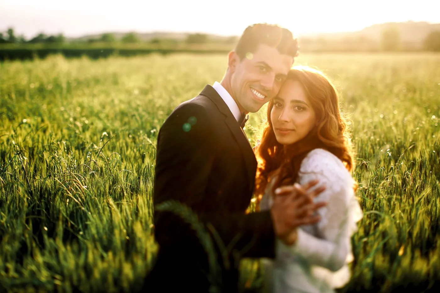 Pareja de novios fotografiada a contraluz en la hora dorada