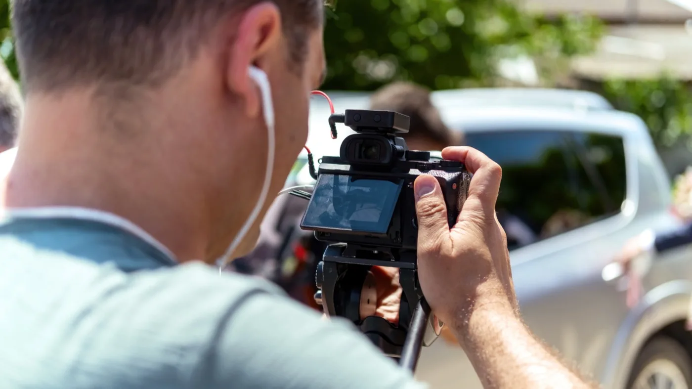 Videógrafo grabando una ceremonia con cámara profesional